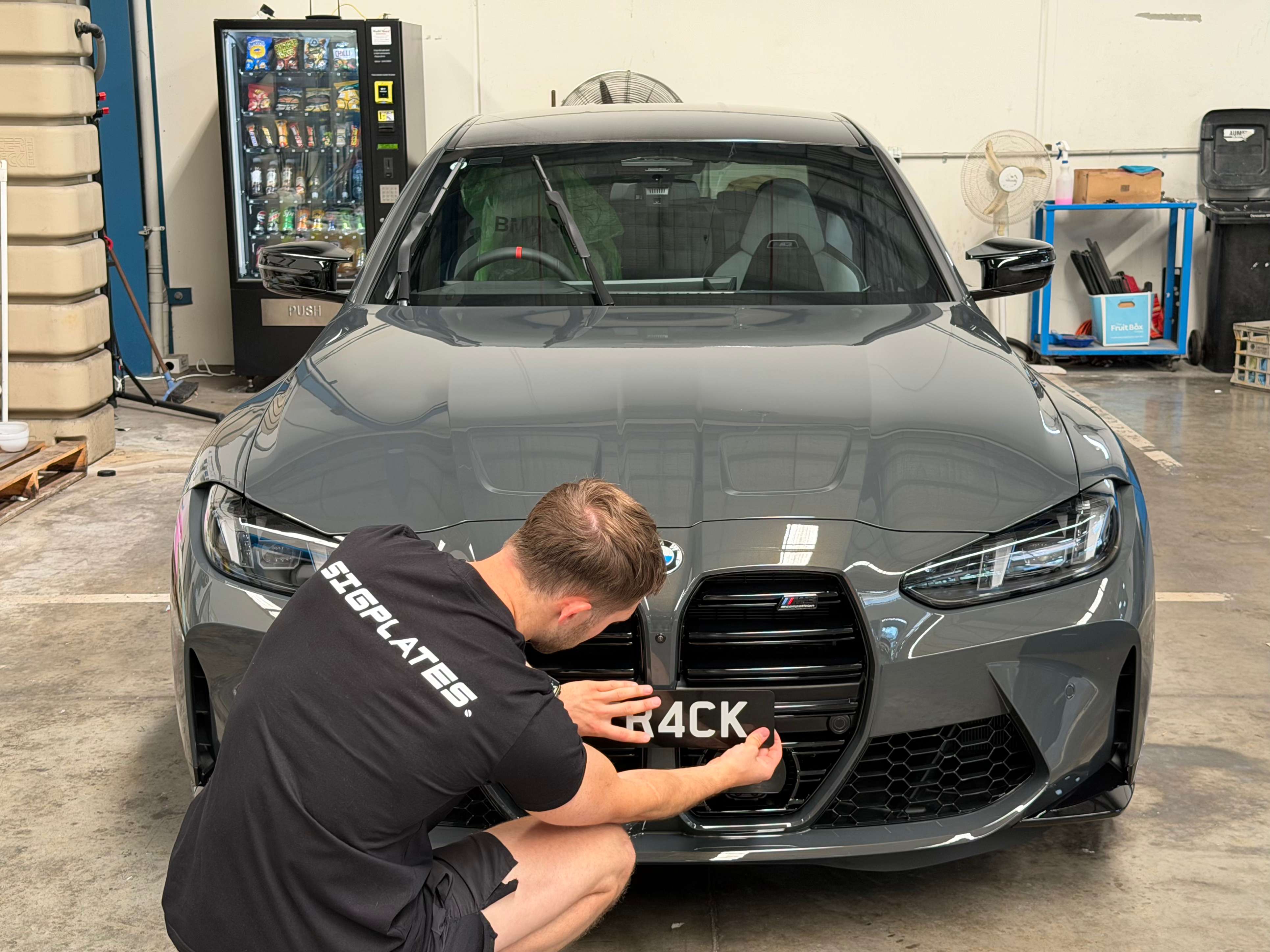 Ethan installing a number plate on a BMW M3